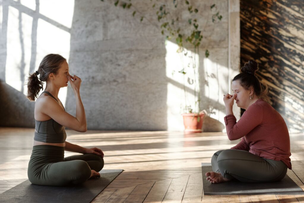 women practicing yoga and mindfulness with focused breathing